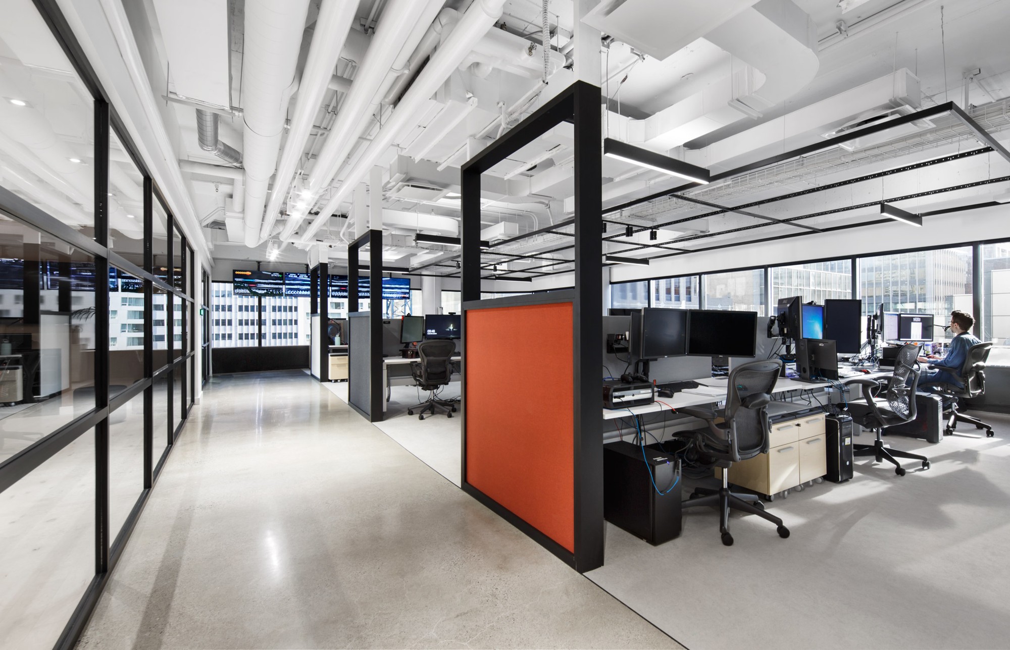 Commercial office interior with glass partitions and exposed building systems, from the BAINS portfolio